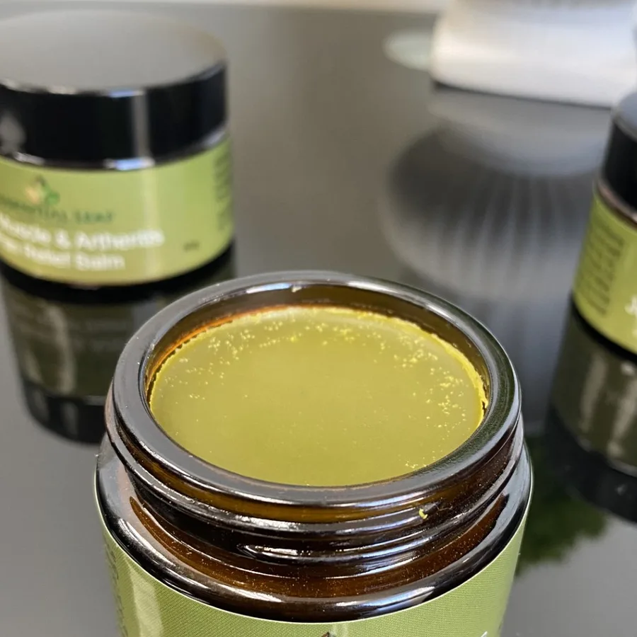 Open jar of Essential Leaf Comfrey & Arnica Balm showing the green botanical balm